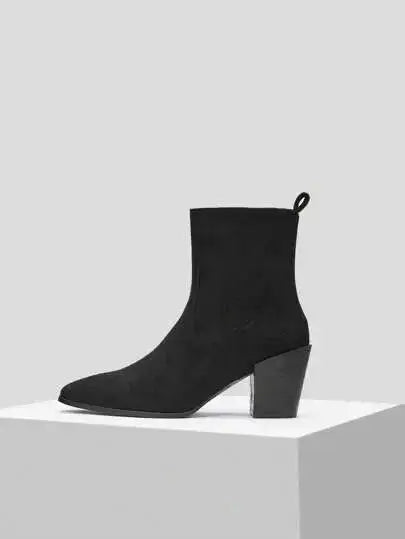 Bottines noires en imitation daim de qualité supérieure. Design élégant avec bout légèrement pointu et fermeture éclair latérale. Talons carrés pour un confort optimal et texture veloutée pour un effet luxueux. Nettoyage à sec recommandé pour maintenir l'éclat du matériau.