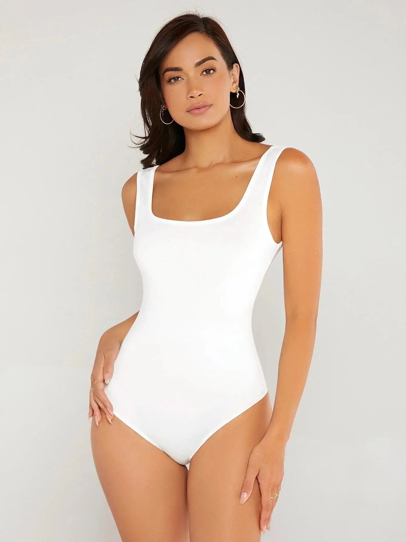 Body à col carré confectionné en polyester (95%) et spandex (5%). Présente une coupe ajustée avec manches longues pour une silhouette chic. Disponible en blanc pur et noir profond. Caractérisé par des finitions fines, coutures discrètes et un excellent maintien. Entretien : lavage à la main ou en machine à froid, cycle délicat.