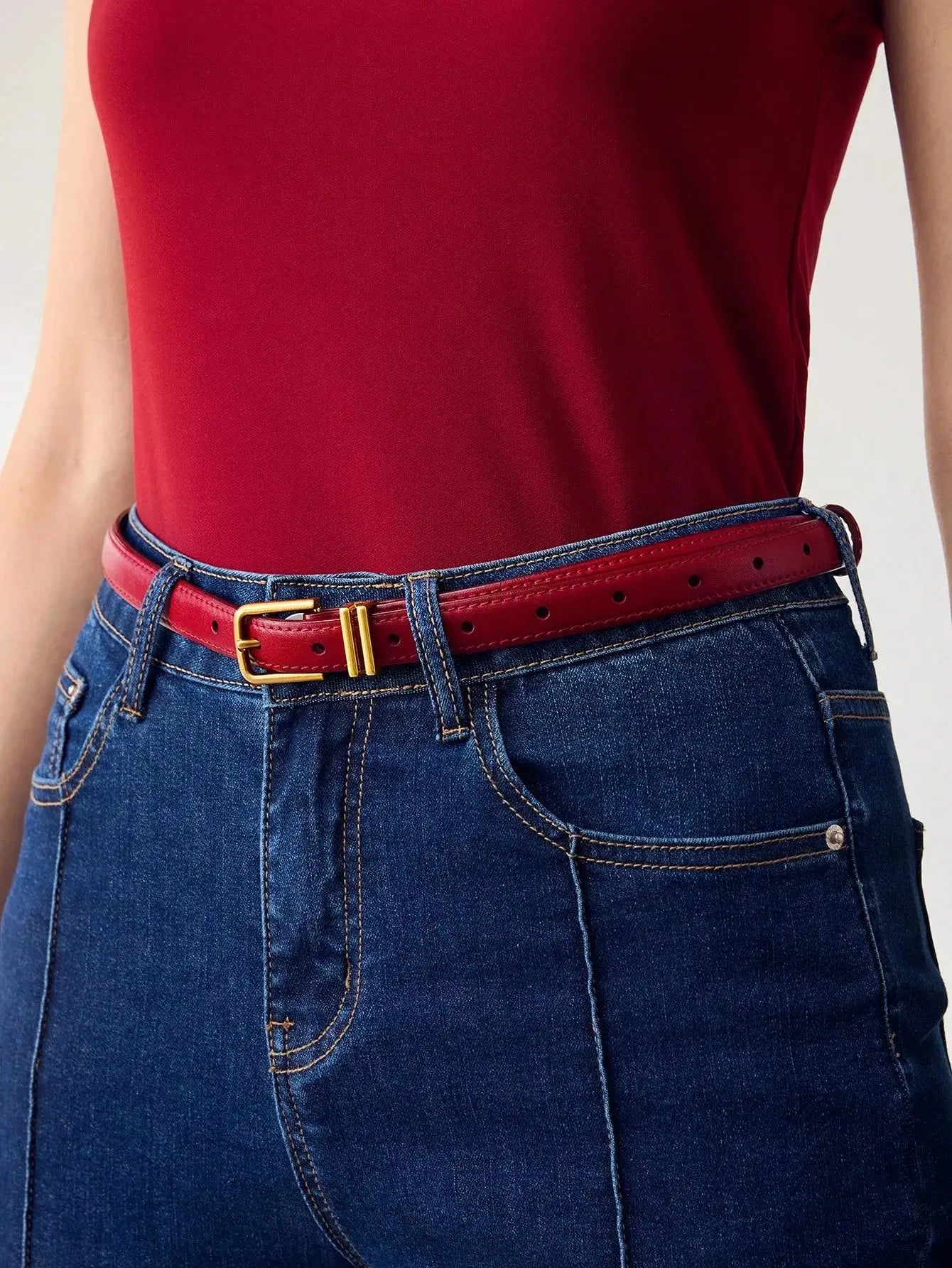 Ceinture femme en similicuir rouge, avec boucle dorée. Design lisse et finition brillante. Conçue pour ajouter une touche chic et contemporaine à vos tenues. Évitez l'exposition prolongée à l'humidité pour en préserver l'éclat.