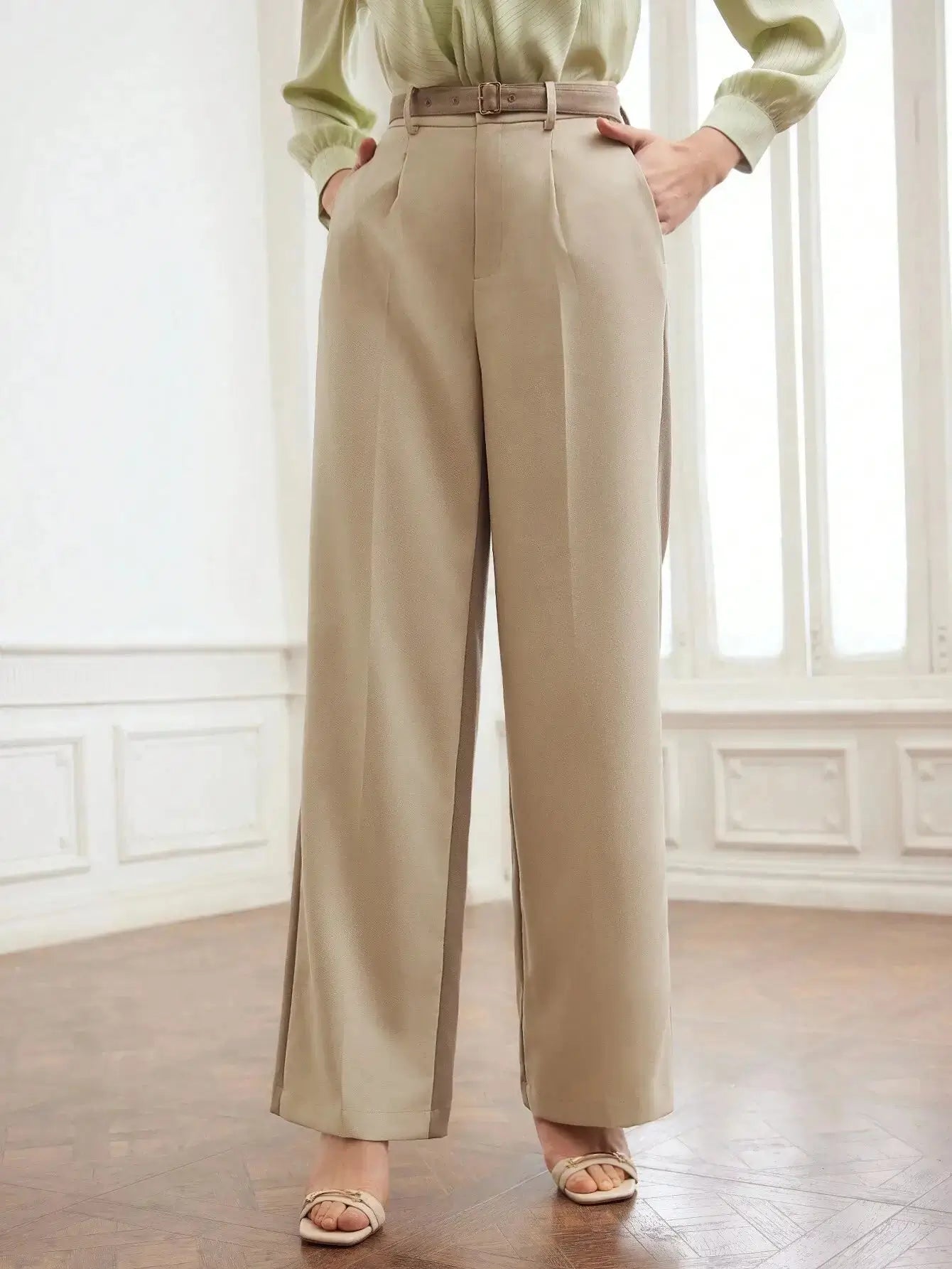 Pantalon en polyester beige, coupe droite avec fermeture éclair, rabat et poches intégrées. Finitions élégantes avec plis raffinés et ceinture. Texture douce et durable. Entretien : lavage en machine ou nettoyage à sec.