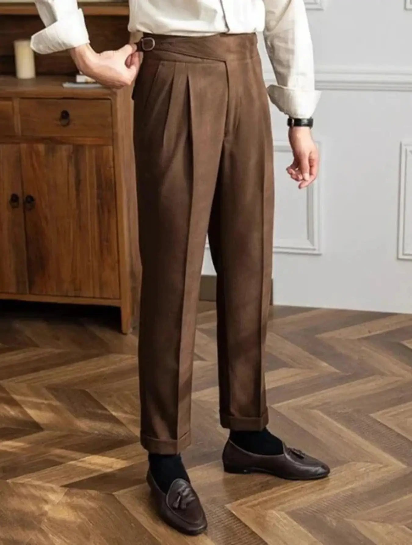 Pantalon taille haute en 100% polyester, résistant aux plis et durable. Coupe droite avec ceinture intégrée, boucle de réglage, plis frontaux et ourlet plié à la cheville. Disponible en blanc cassé, marron et marron clair. Tissu légèrement texturé, doux, avec poches latérales. Lavage en machine à froid recommandé.