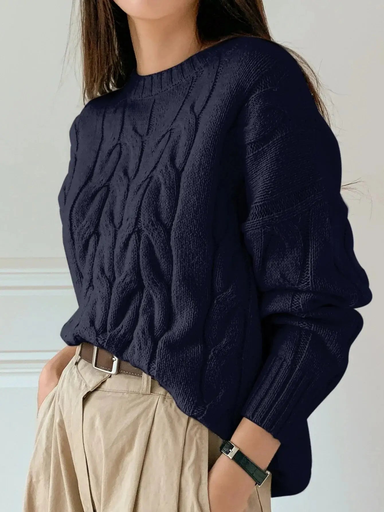 Pull torsadé en tricot bleu marine, confectionné en laine de haute qualité. Coupe ample avec col rond et manches longues, doté de poignets côtelés. Design sophistiqué avec motif torsadé subtil et finitions soignées. Lavage à la main recommandé pour préserver sa douceur et son allure élégante.