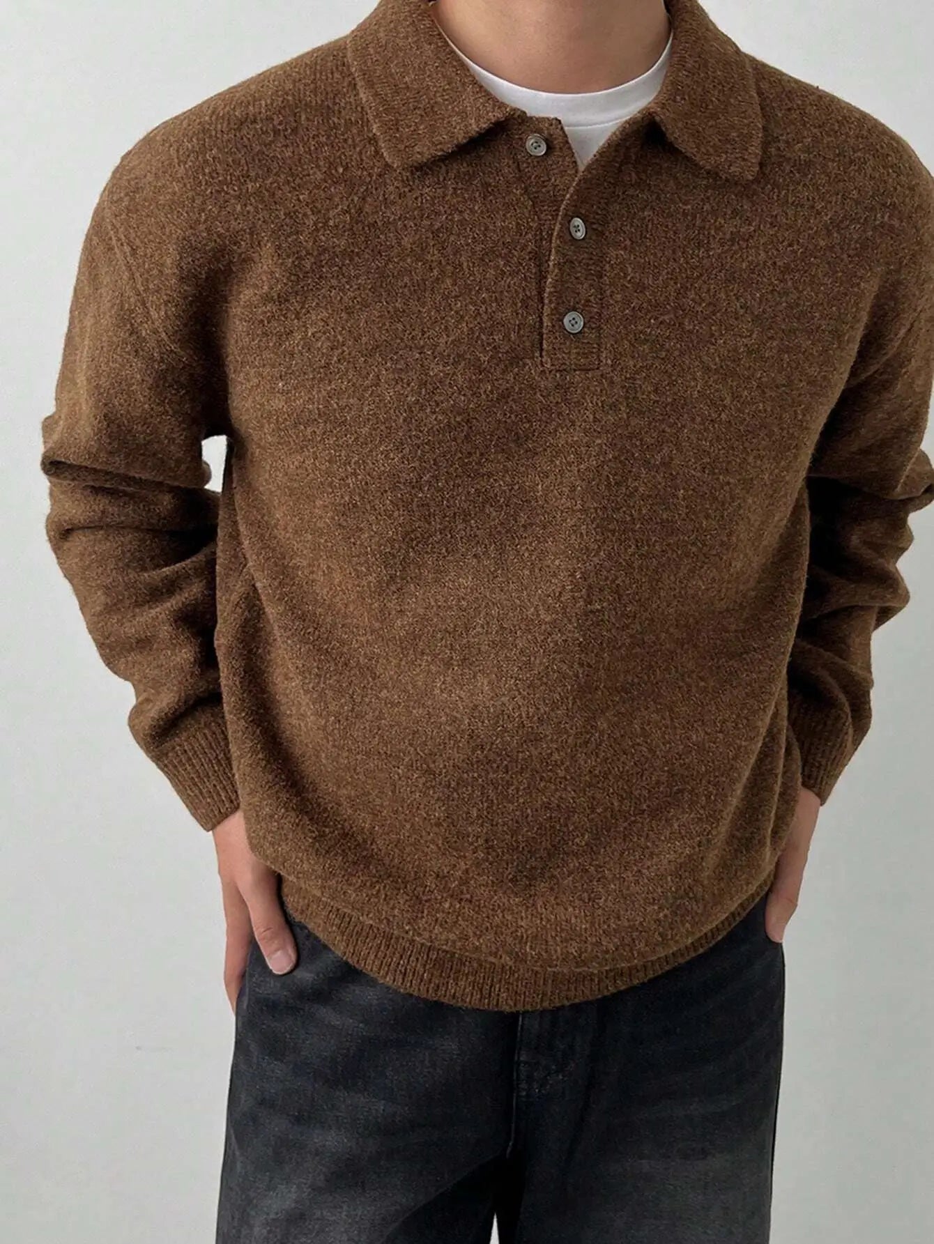 Pull tricoté marron pour homme en mélange de laine et polyester. Doté d'un col boutonné sophistiqué, de manches longues et d'une coupe droite. Poignets et taille côtelés ajoutent au confort. Couleur marron intemporelle pour complémenter toutes les tenues. Texture tricotée délicate, idéale pour l'hiver. Entretien : lavage délicat à la main ou en machine.