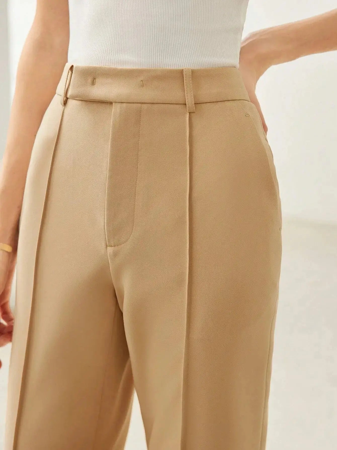 Pantalon évasé en tissu de haute qualité, alliant confort et élégance grâce à sa coupe régulière et sa taille haute. Confectionné en 92% polyester et 8% élasthanne, il présente des jambes évasées et des coutures avant pour une silhouette sophistiquée. Disponible en beige intemporel, il est doté de poches fonctionnelles et d'une fermeture par bouton. Nettoyage à sec recommandé pour préserver son aspect.