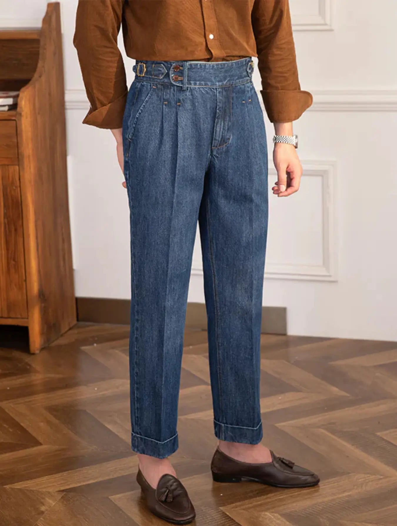 Pantalon en jean taille haute, coupe rétro ample, ceinture ajustable, poches latérales. Disponible en bleu clair ou foncé. Lavage à froid conseillé.