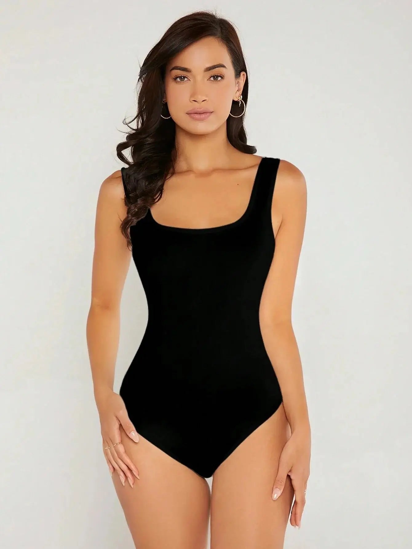 Body à col carré confectionné en polyester (95%) et spandex (5%). Présente une coupe ajustée avec manches longues pour une silhouette chic. Disponible en blanc pur et noir profond. Caractérisé par des finitions fines, coutures discrètes et un excellent maintien. Entretien : lavage à la main ou en machine à froid, cycle délicat.