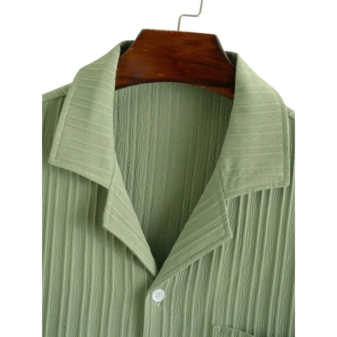 Chemise 100% coton léger et respirant, col classique, manches courtes. Disponible en vert pastel, fermeture boutonnée à l'avant et plis verticaux subtils. Lavage en machine à froid recommandé.