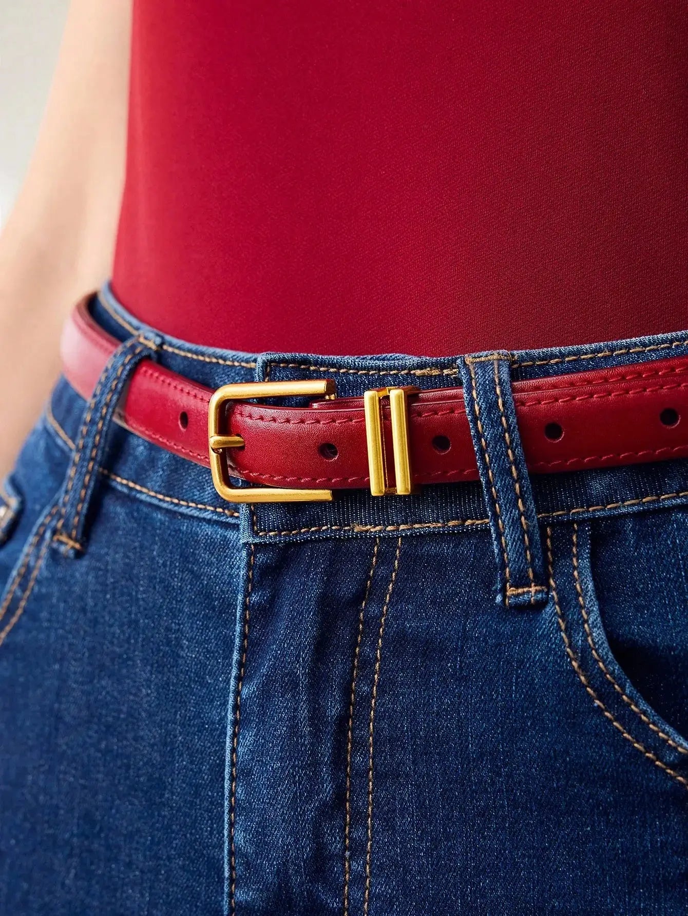 Ceinture femme en similicuir rouge, avec boucle dorée. Design lisse et finition brillante. Conçue pour ajouter une touche chic et contemporaine à vos tenues. Évitez l'exposition prolongée à l'humidité pour en préserver l'éclat.