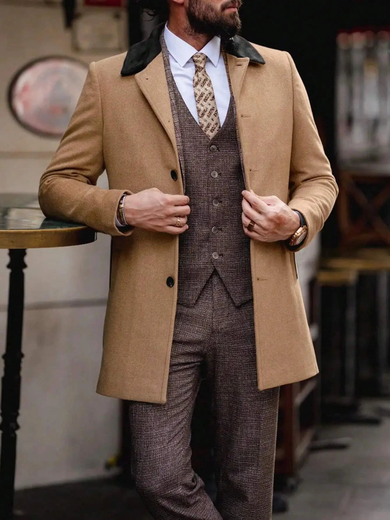 Manteau camel en mélange de laine (70% laine, 27% acrylique, 3% élasthanne) affichant un design classique avec col à revers noir contrastant. Coupe régulière et manches longues, agrémentée de boutons sur le devant et poches intégrées. Lavage en machine ou nettoyage à sec recommandé.