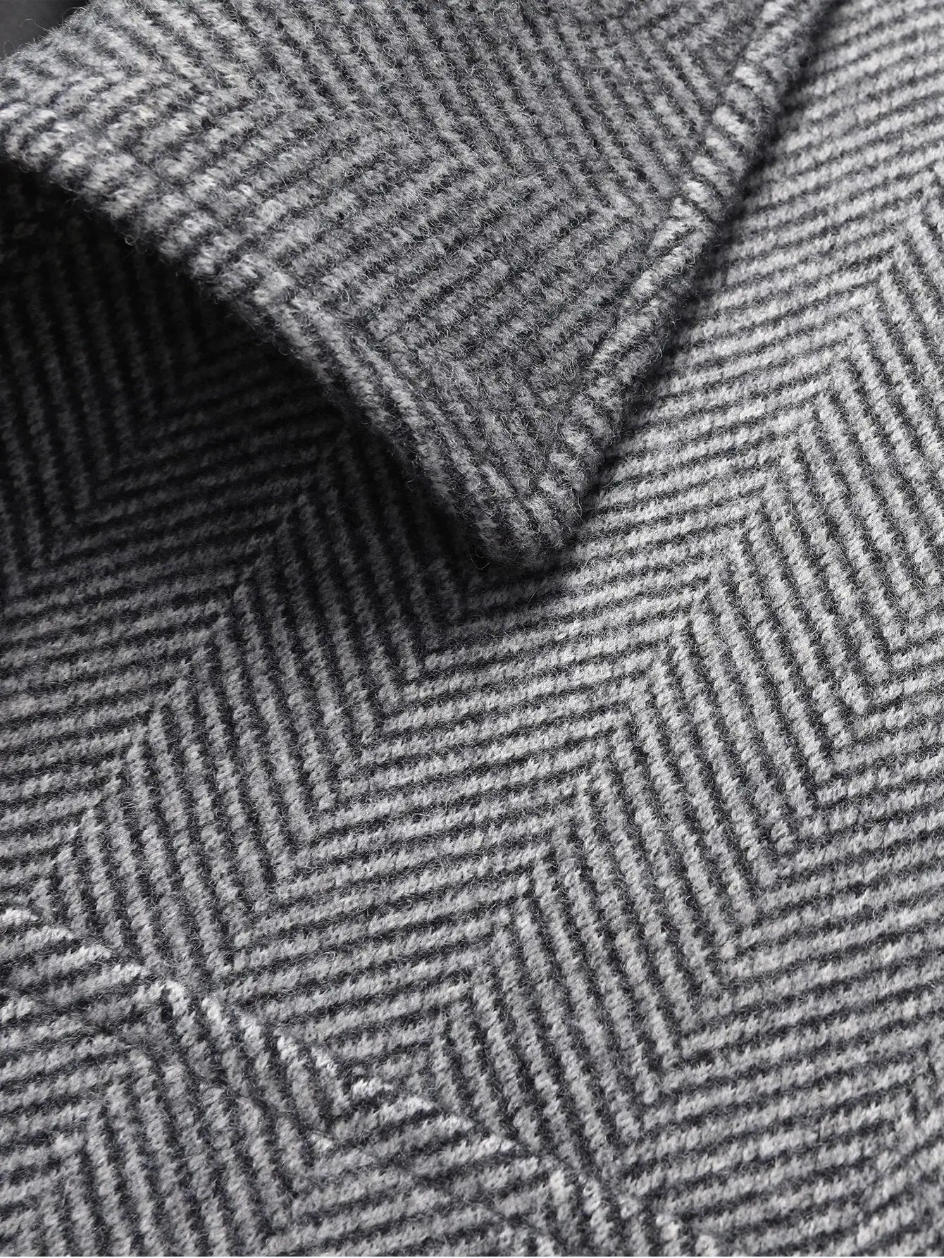 Manteau d'hiver en laine de qualité supérieure à motif chevrons. Coupe droite avec col classique et manches longues pour une silhouette élégante. Disponible en gris anthracite, bleu marine et marron châtaigne. Précision des détails et finition méticuleuse. Nettoyage à sec conseillé.