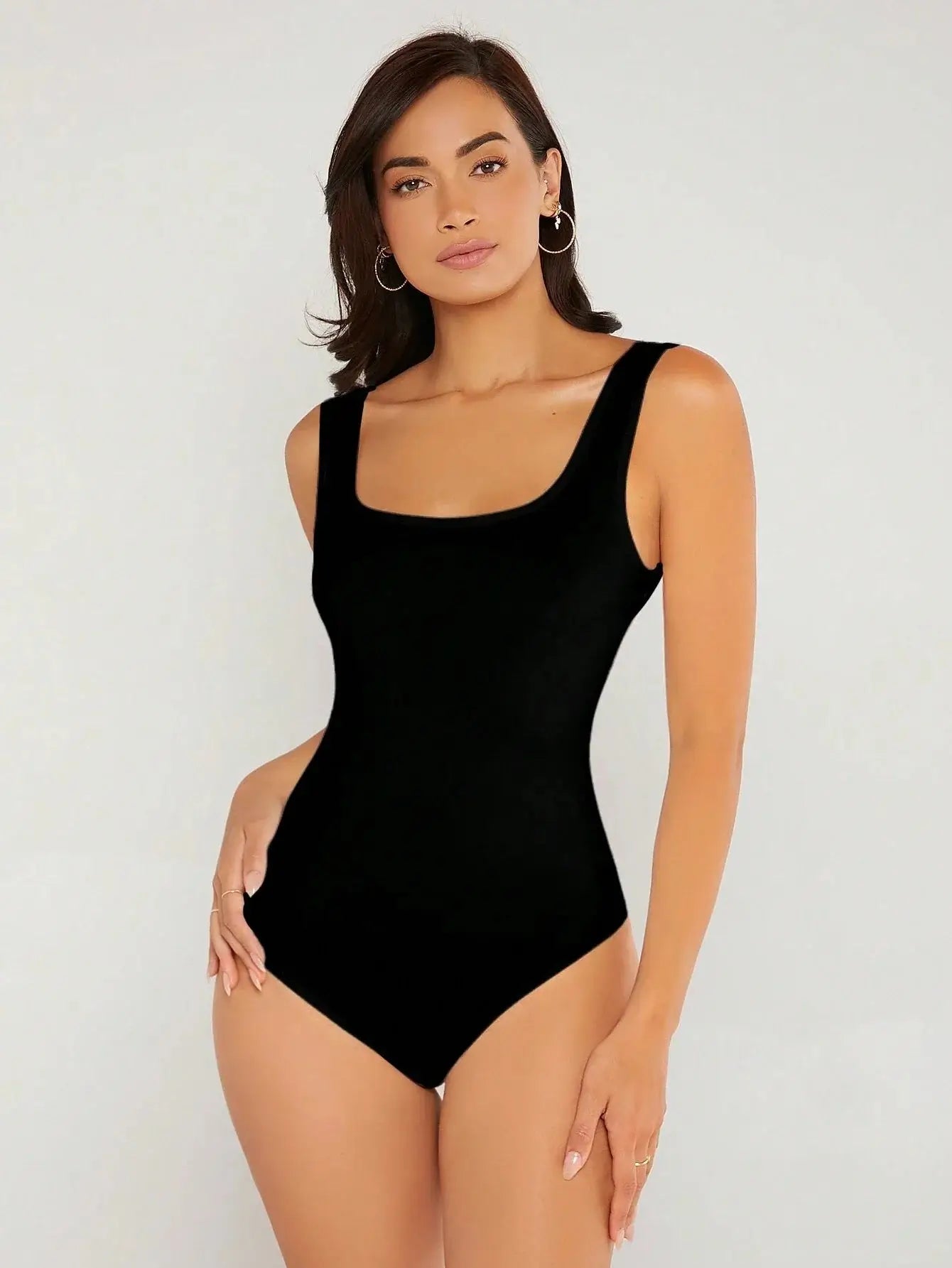 Body à col carré confectionné en polyester (95%) et spandex (5%). Présente une coupe ajustée avec manches longues pour une silhouette chic. Disponible en blanc pur et noir profond. Caractérisé par des finitions fines, coutures discrètes et un excellent maintien. Entretien : lavage à la main ou en machine à froid, cycle délicat.