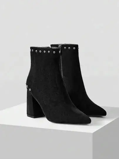 Bottines en suédine noire de qualité supérieure, au design chic avec un bout légèrement pointu et une fermeture éclair latérale. Ornées de clous décoratifs pour un style audacieux, elles possèdent un talon carré épais garantissant confort et stabilité. Couleur noire classique. Nettoyage à la main recommandé pour préserver l'apparence du faux daim.