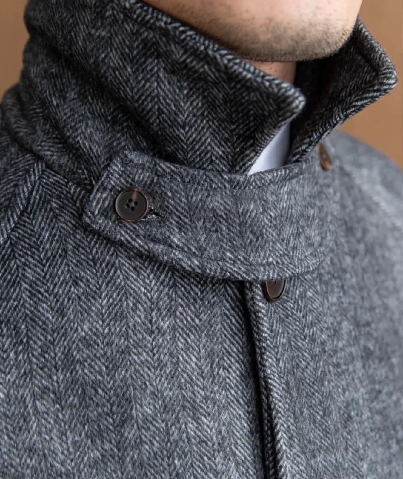 Manteau ceinturé en mélange de polyester et laine, assurant confort et chaleur. Il présente une fermeture à boutons, un col montant avec option boutonnée et des poches latérales. Disponible en gris foncé et beige clair, il dispose d'une ceinture intégrée pour un ajustement personnalisé et de manches longues avec boutons aux poignets. Nettoyage à sec recommandé.