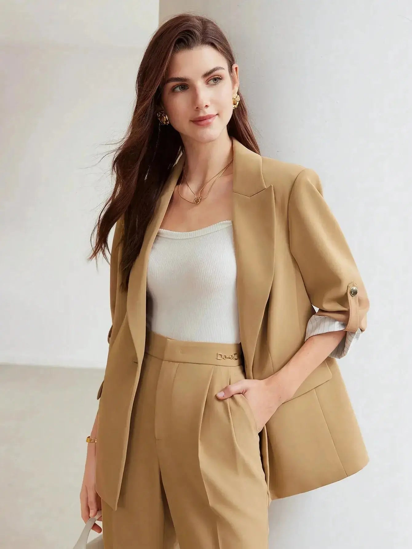 Blazer beige en polyester, tissé non extensible. Présente une coupe large avec revers, manches mi-longues retroussées et boutons décoratifs. Équipé de poches intégrées et offre une longueur classique non transparente. Disponible en beige pour une élégance discrète. Entretien par lavage en machine ou nettoyage à sec recommandé.