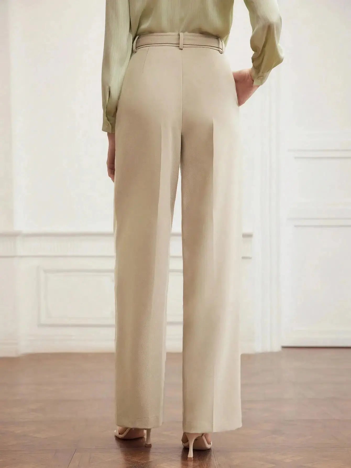 Pantalon en polyester beige, coupe droite avec fermeture éclair, rabat et poches intégrées. Finitions élégantes avec plis raffinés et ceinture. Texture douce et durable. Entretien : lavage en machine ou nettoyage à sec.