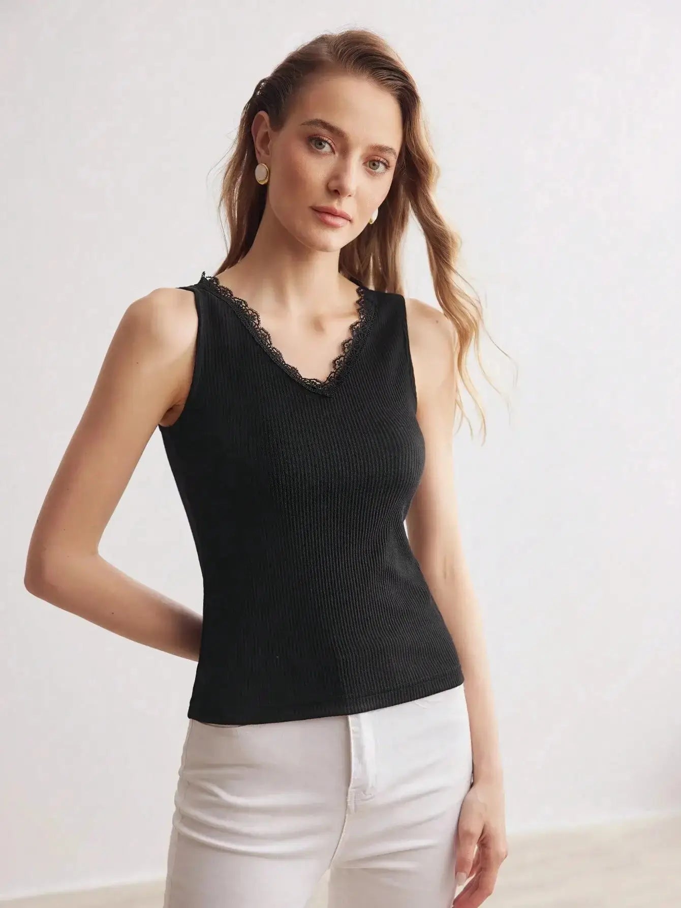 Débardeur en tricot côtelé noir, alliant confort et élégance. Confectionné dans un mélange de 65% polyester, 30% coton, et 5% élasthanne, il offre douceur et extensibilité. Son design présente une encolure en V embellie de dentelle, avec une coupe ajustée et une texture côtelée. Disponible en noir, il se distingue par sa dentelle contrastée et ses finitions soignées. Lavable en machine pour un entretien aisé.