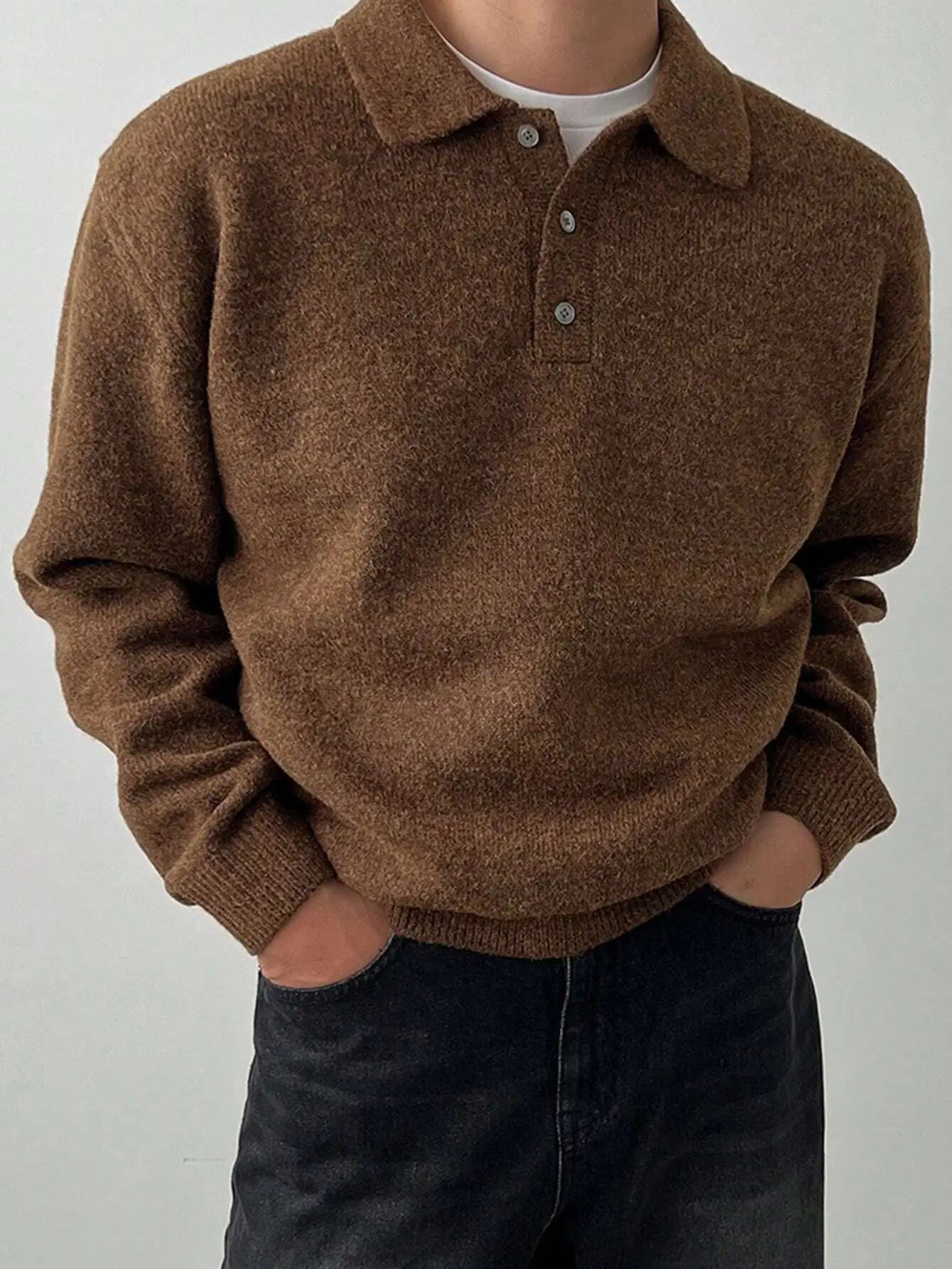 Pull tricoté marron pour homme en mélange de laine et polyester. Doté d'un col boutonné sophistiqué, de manches longues et d'une coupe droite. Poignets et taille côtelés ajoutent au confort. Couleur marron intemporelle pour complémenter toutes les tenues. Texture tricotée délicate, idéale pour l'hiver. Entretien : lavage délicat à la main ou en machine.