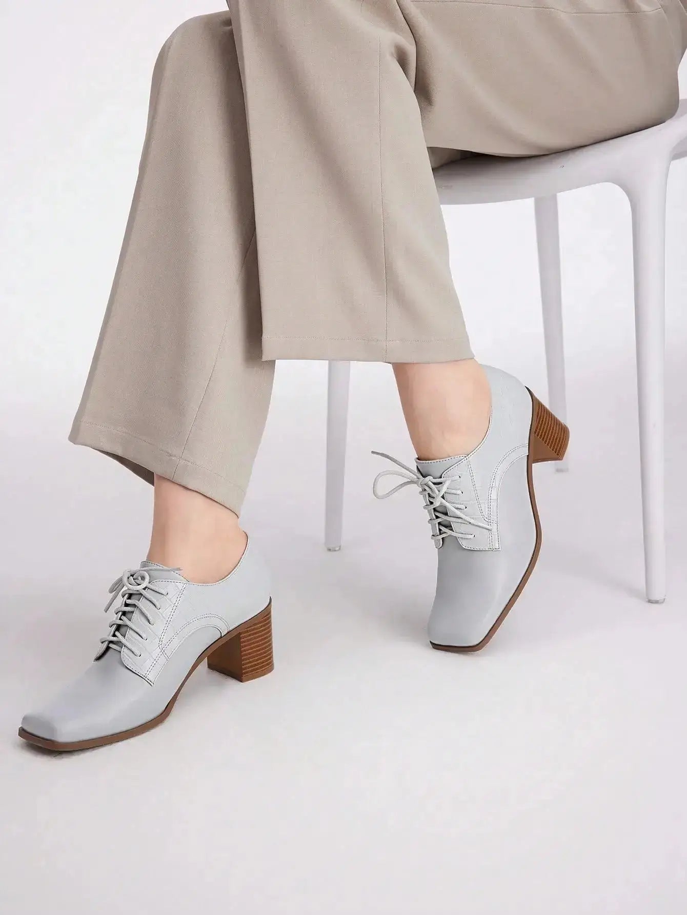 Chaussures Anglaise Talon Carré en similicuir haut de gamme. Design épuré avec bout carré et talon épais de hauteur moyenne pour un confort optimal. Disponible en gris classique, ces chaussures présentent un motif uni et des lacets raffinés. Pour l'entretien, nettoyer avec un chiffon doux et sec.