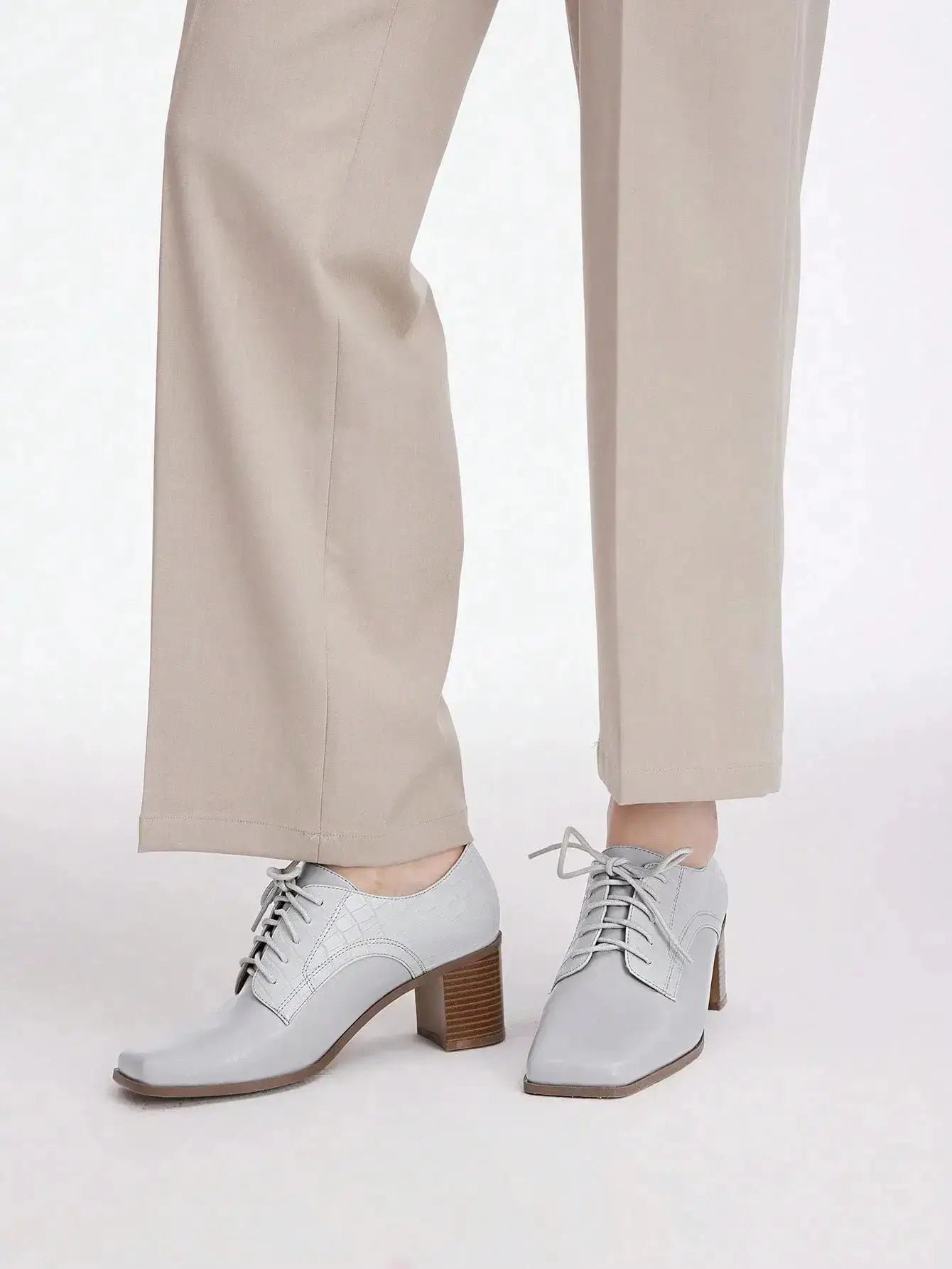 Chaussures Anglaise Talon Carré en similicuir haut de gamme. Design épuré avec bout carré et talon épais de hauteur moyenne pour un confort optimal. Disponible en gris classique, ces chaussures présentent un motif uni et des lacets raffinés. Pour l'entretien, nettoyer avec un chiffon doux et sec.