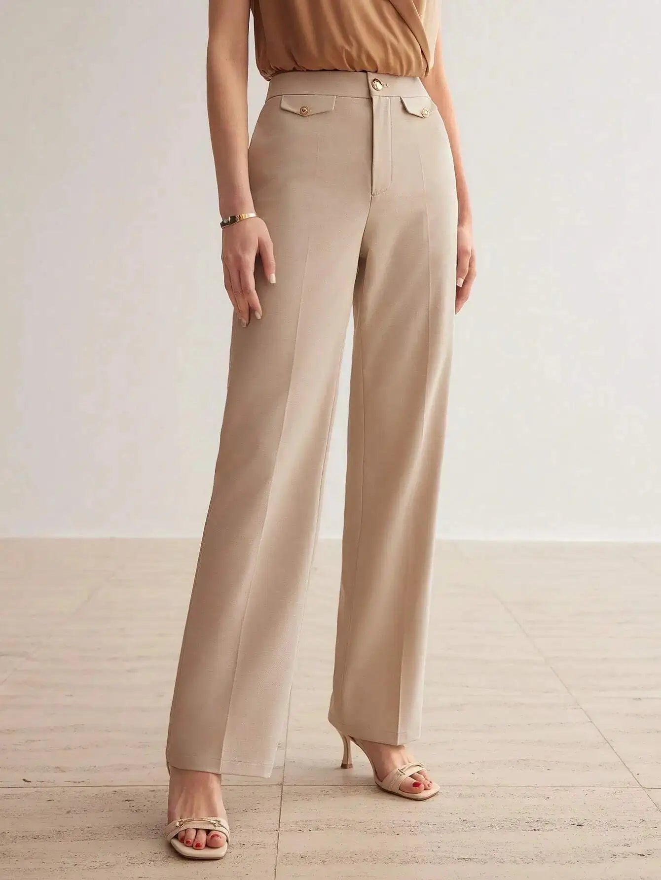 Pantalon en 100% polyester de haute qualité, offrant une texture douce et durable. Coupe droite raffinée avec fermeture éclair, rabat, et poches intégrées. Teinte beige sophistiquée. Finitions élégantes avec ceinture intégrée et plis soignés. Entretien : lavage en machine ou nettoyage à sec recommandé.