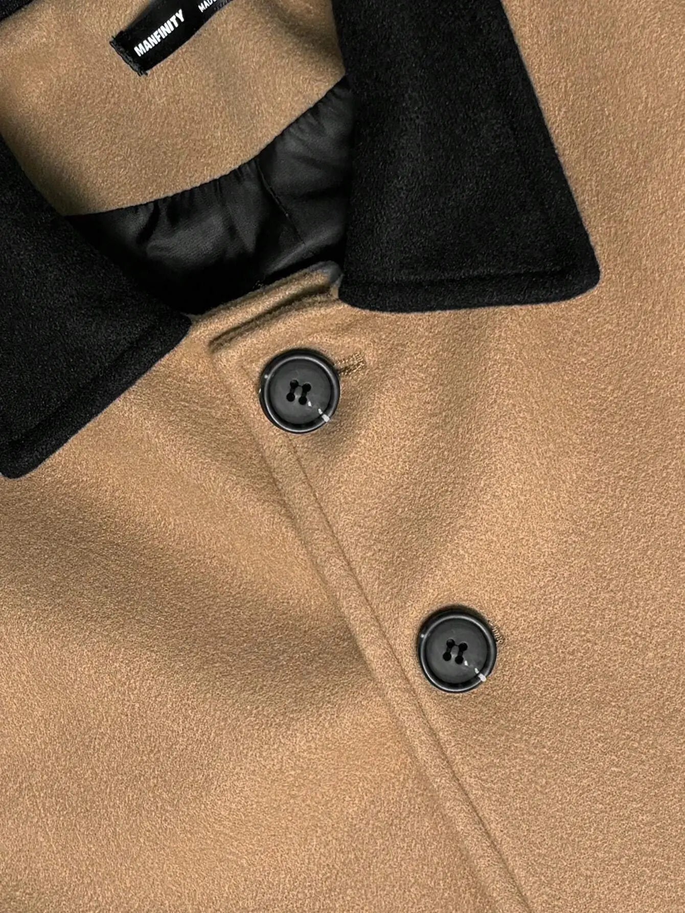 Manteau camel en mélange de laine (70% laine, 27% acrylique, 3% élasthanne) affichant un design classique avec col à revers noir contrastant. Coupe régulière et manches longues, agrémentée de boutons sur le devant et poches intégrées. Lavage en machine ou nettoyage à sec recommandé.