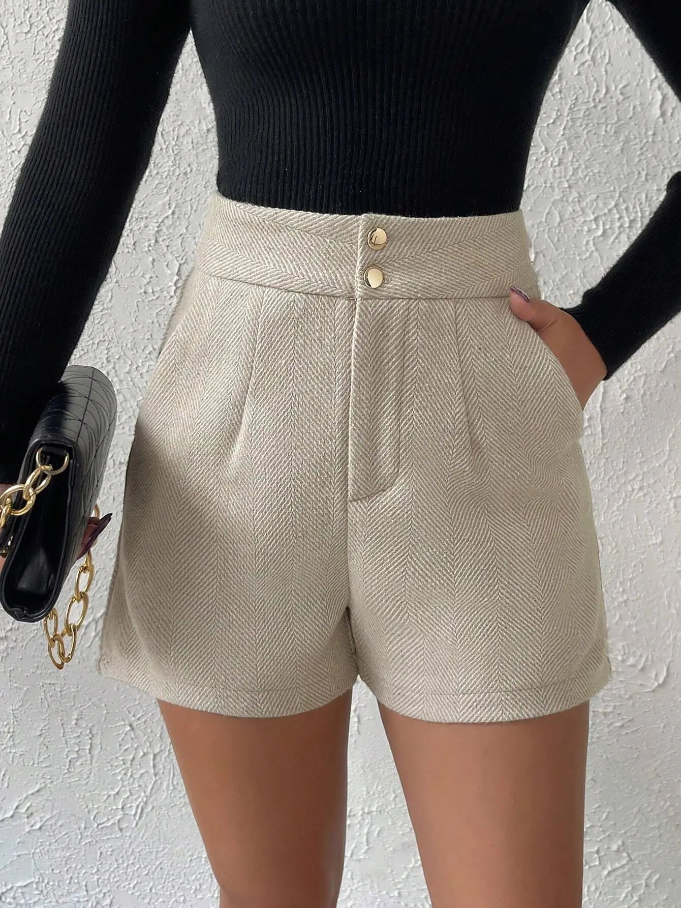 Short à chevrons beige, élégant et sophistiqué. Taille haute ajustée, détails plissés à l'avant, poches latérales et deux boutons dorés à la taille. Confectionné en mélange de fibres naturelles et synthétiques pour une texture structurée. Lavage à la main ou en machine à 30°C recommandé.