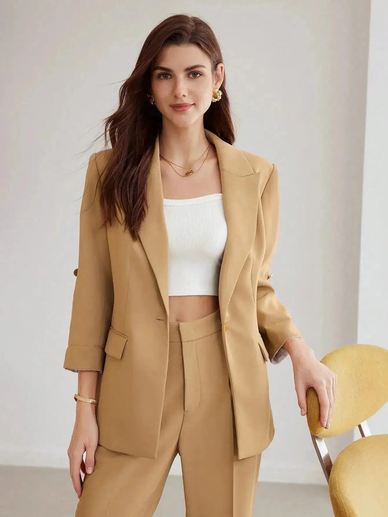 Blazer beige en polyester, tissé non extensible. Présente une coupe large avec revers, manches mi-longues retroussées et boutons décoratifs. Équipé de poches intégrées et offre une longueur classique non transparente. Disponible en beige pour une élégance discrète. Entretien par lavage en machine ou nettoyage à sec recommandé.