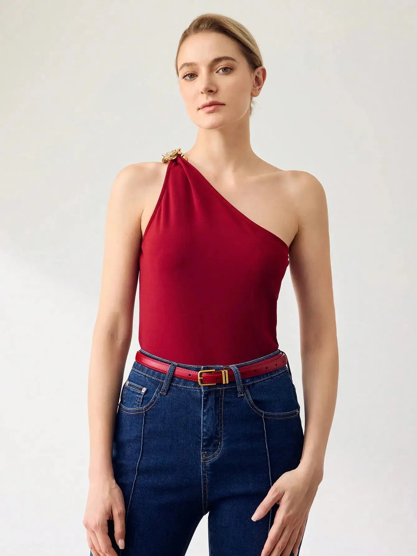 Ceinture femme en similicuir rouge, avec boucle dorée. Design lisse et finition brillante. Conçue pour ajouter une touche chic et contemporaine à vos tenues. Évitez l'exposition prolongée à l'humidité pour en préserver l'éclat.