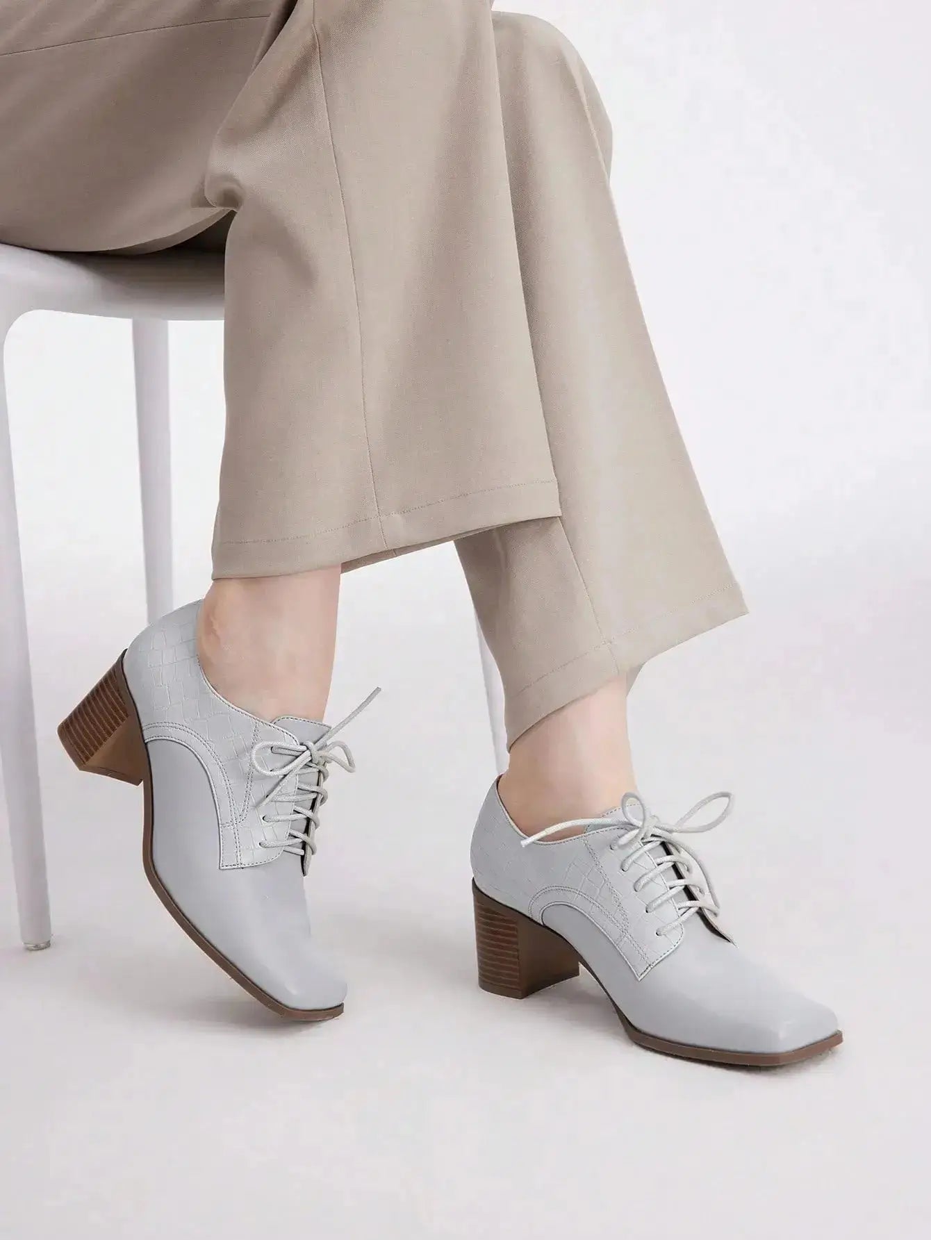 Chaussures Anglaise Talon Carré en similicuir haut de gamme. Design épuré avec bout carré et talon épais de hauteur moyenne pour un confort optimal. Disponible en gris classique, ces chaussures présentent un motif uni et des lacets raffinés. Pour l'entretien, nettoyer avec un chiffon doux et sec.