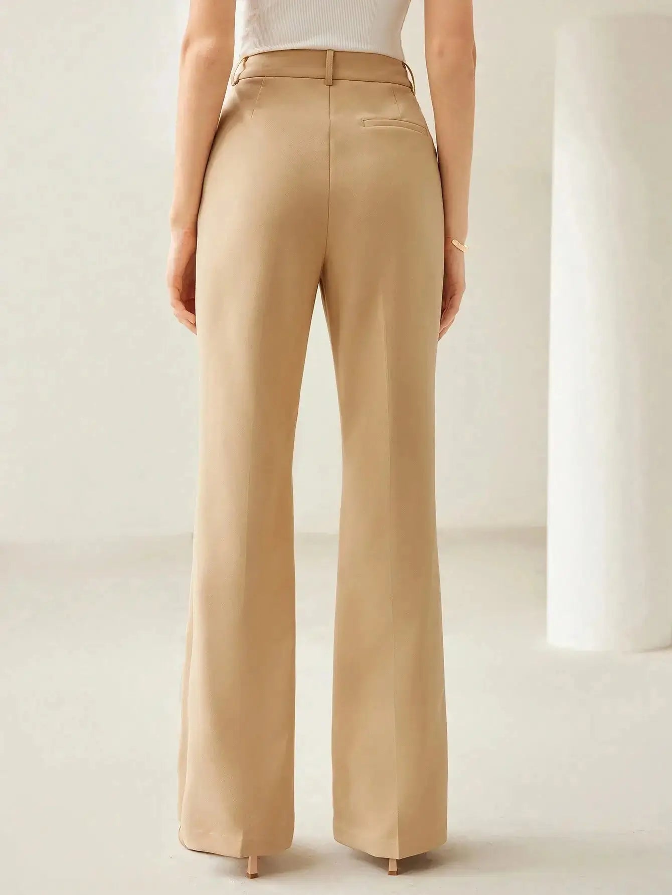 Pantalon évasé en tissu de haute qualité, alliant confort et élégance grâce à sa coupe régulière et sa taille haute. Confectionné en 92% polyester et 8% élasthanne, il présente des jambes évasées et des coutures avant pour une silhouette sophistiquée. Disponible en beige intemporel, il est doté de poches fonctionnelles et d'une fermeture par bouton. Nettoyage à sec recommandé pour préserver son aspect.