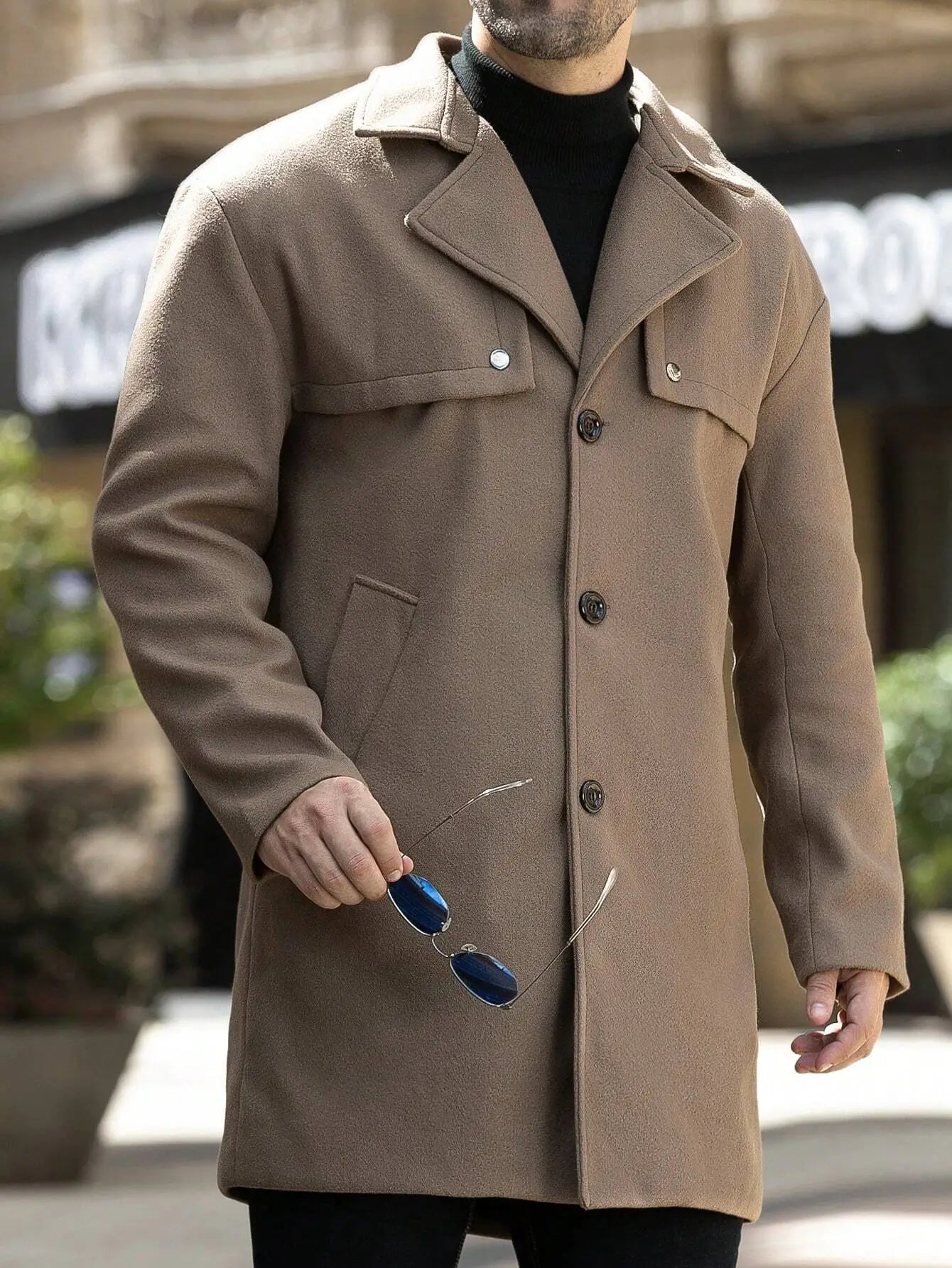 Trench marron en polyester tissé de qualité, légèrement extensible. Coupe régulière avec col à revers, manches longues, boutons distinctifs et poches avant pratiques. Design unicolore élégant. Lavable en machine ou nettoyage à sec recommandé.