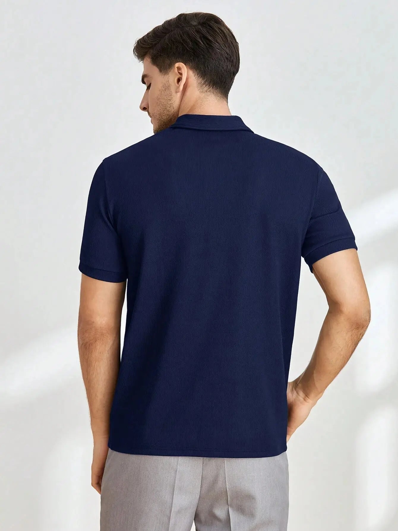 Polo zippé à manches courtes en mélange de coton et fibres synthétiques, alliant confort et respirabilité. Il présente un col polo classique, une fermeture éclair courte et une coupe droite légèrement ajustée. Disponible en bleu marine avec finitions côtelées aux manches et à l'ourlet. Lavage en machine à froid recommandé pour préserver la qualité.