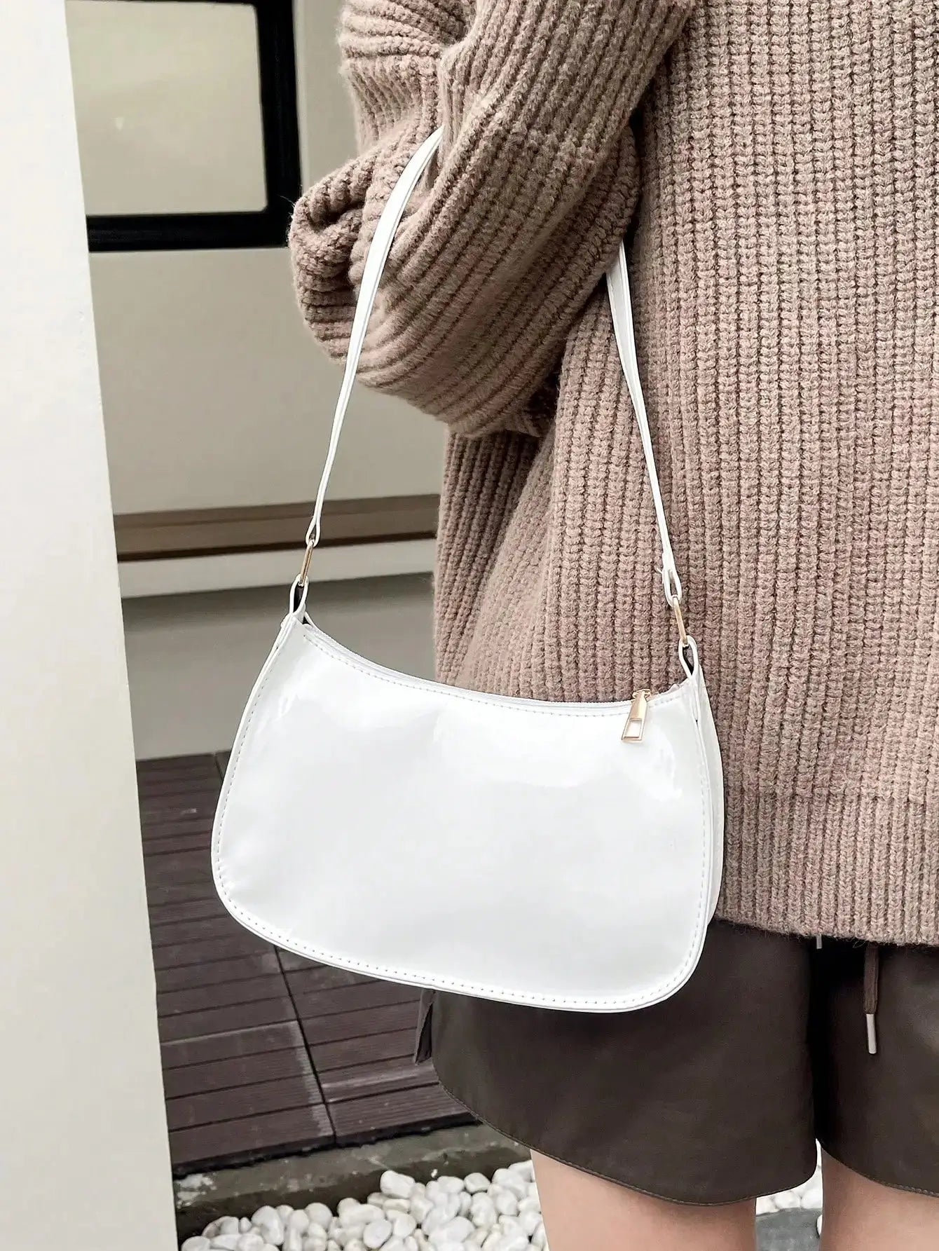 Sac à main demi-lune en simili cuir blanc brillant, au design minimaliste et élégant. Il dispose d'une bandoulière fine et d'une fermeture éclair dorée. Compact, il ajoute une touche sophistiquée à vos tenues. Dimensions : 24,5 cm (longueur), 17 cm (hauteur), 7 cm (profondeur). Nettoyage avec un chiffon doux et sec recommandé.