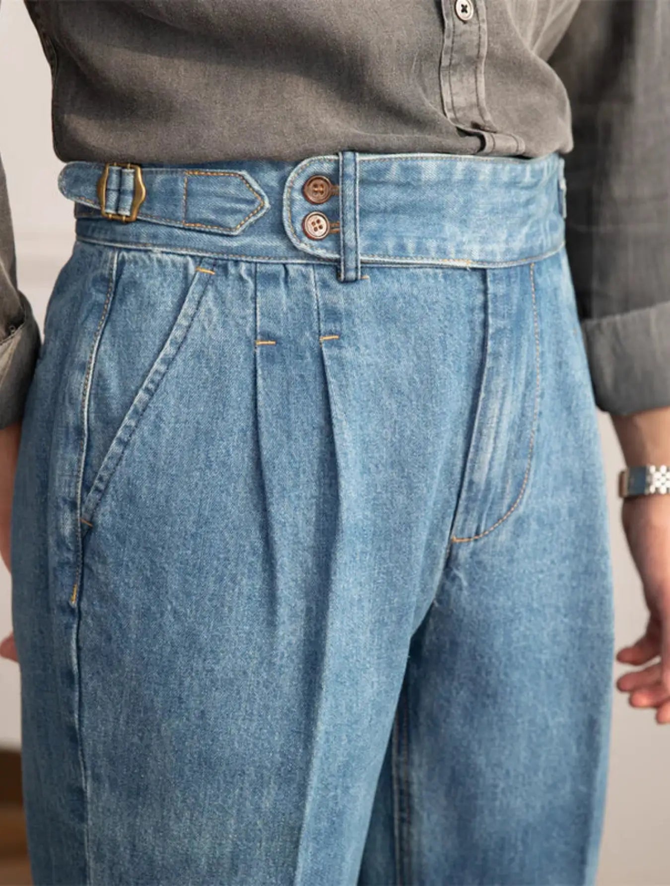 Pantalon en jean taille haute, coupe rétro ample, ceinture ajustable, poches latérales. Disponible en bleu clair ou foncé. Lavage à froid conseillé.