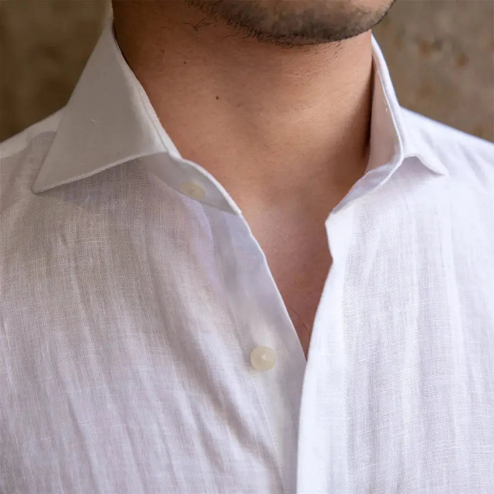 Chemise 100% coton léger et respirant, col classique et manches courtes. Disponible en vert pastel, avec fermeture boutonnée et plis verticaux subtils. Lavage en machine à froid recommandé.