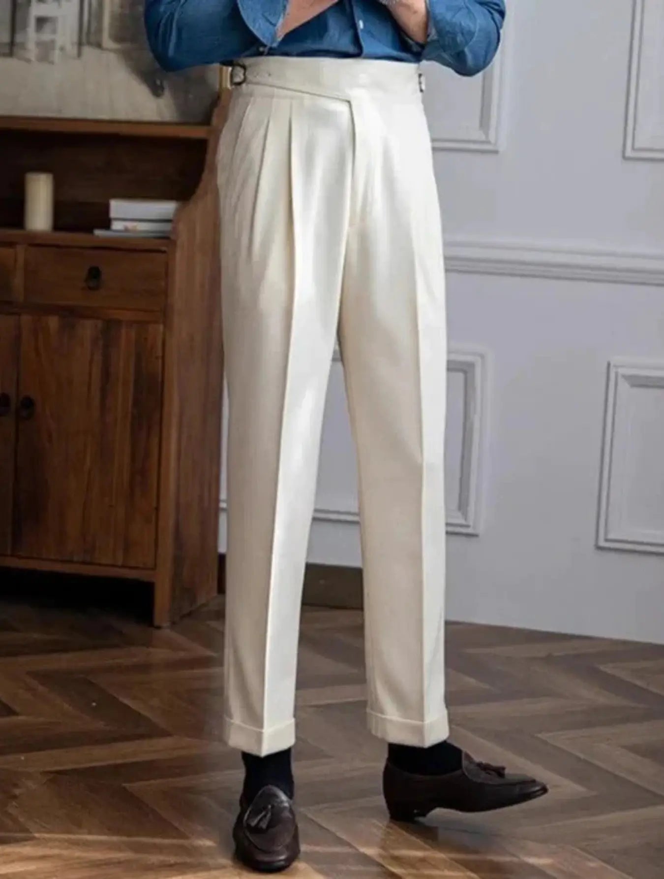 Pantalon taille haute en 100% polyester, résistant aux plis et durable. Coupe droite avec ceinture intégrée, boucle de réglage, plis frontaux et ourlet plié à la cheville. Disponible en blanc cassé, marron et marron clair. Tissu légèrement texturé, doux, avec poches latérales. Lavage en machine à froid recommandé.