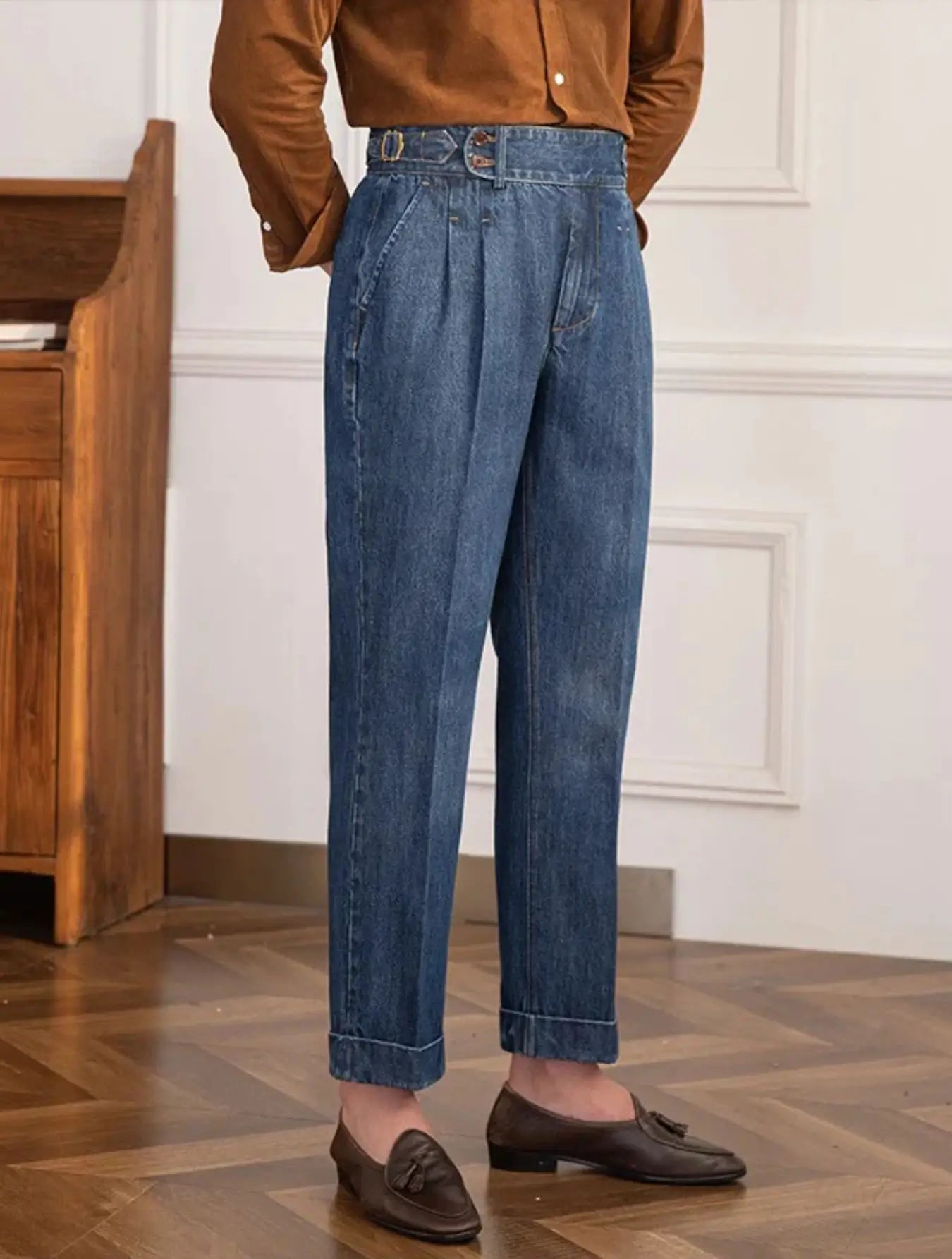 Pantalon en jean taille haute, coupe rétro ample, ceinture ajustable, poches latérales. Disponible en bleu clair ou foncé. Lavage à froid conseillé.