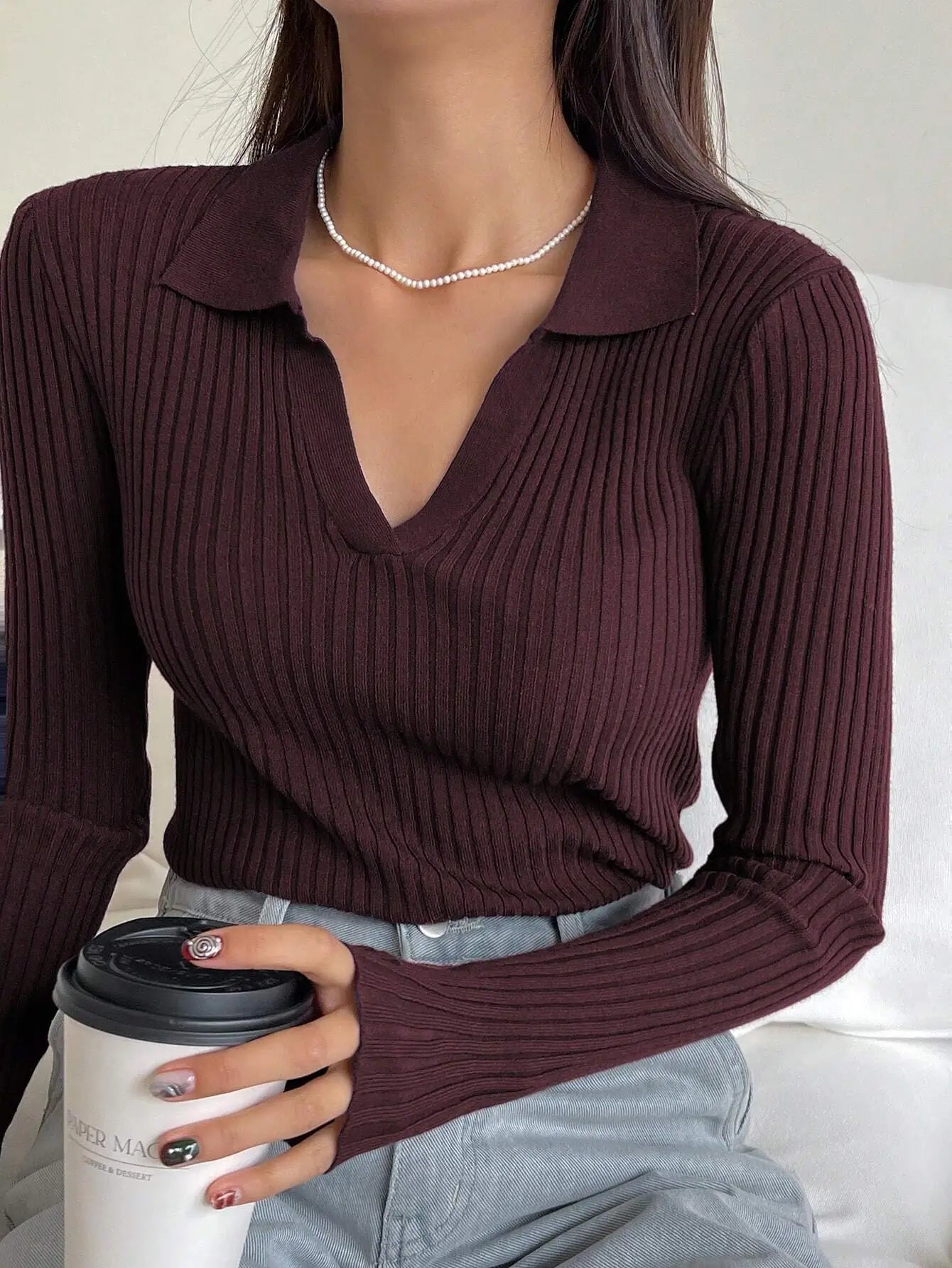 Top côtelé à col chemise, couleur bordeaux foncé. Composition : 50% viscose, 30% polyester, 20% polyamide. Coupe ajustée, manches longues. Design épuré avec texture en relief. Idéal pour un style casual et confortable, adapté au printemps et à l'automne. Entretien : lavage à la main ou nettoyage à sec recommandé.