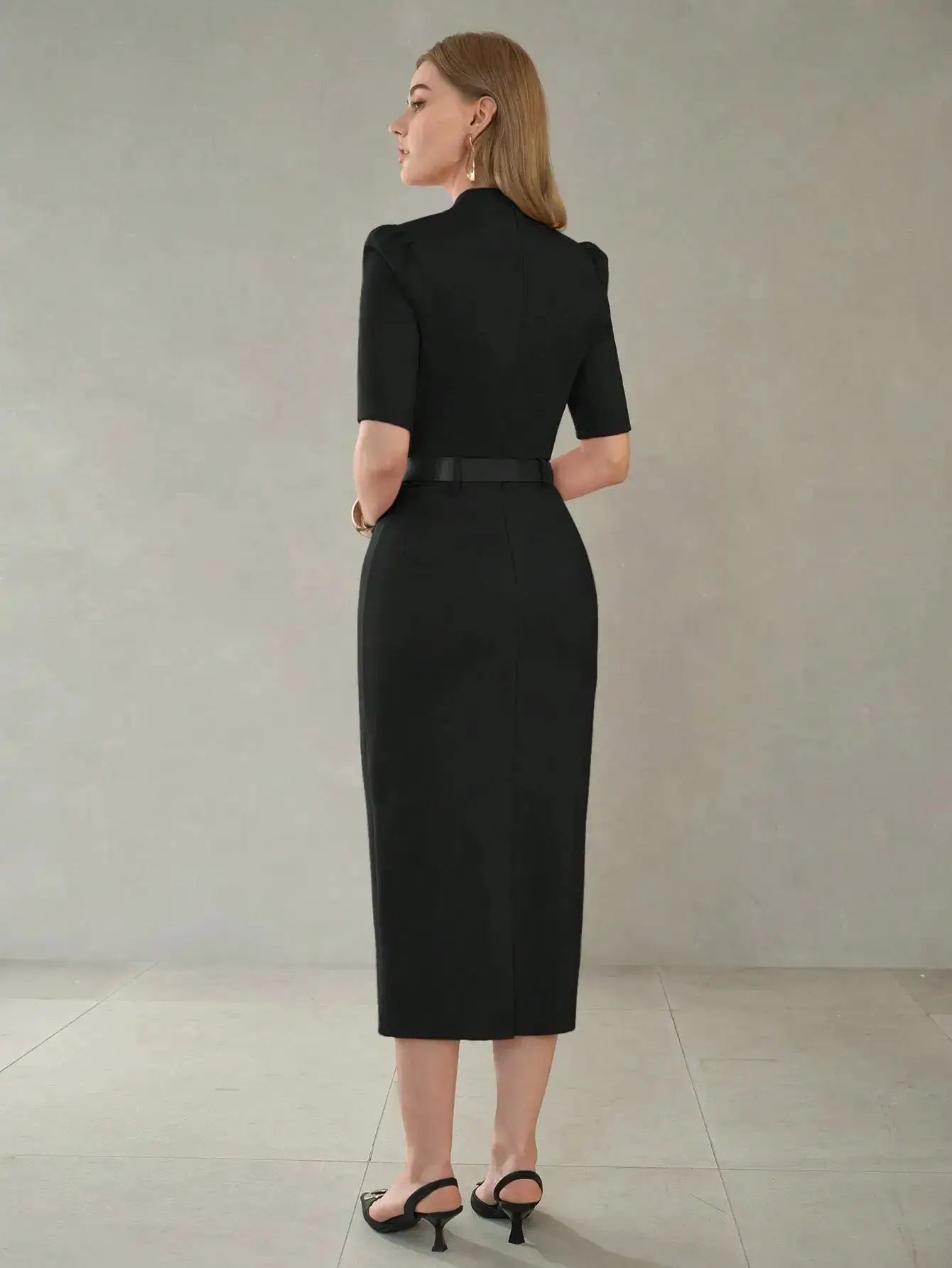 Robe midi noire raffinée à manches bouffantes, ceinturée avec fente et col châle. Fabriquée avec 65% viscose, 30% polyamide, 5% élasthanne et doublure en 100% polyester. Tissu uni légèrement extensible, sans transparence. Entretien délicat conseillé pour préserver sa qualité.