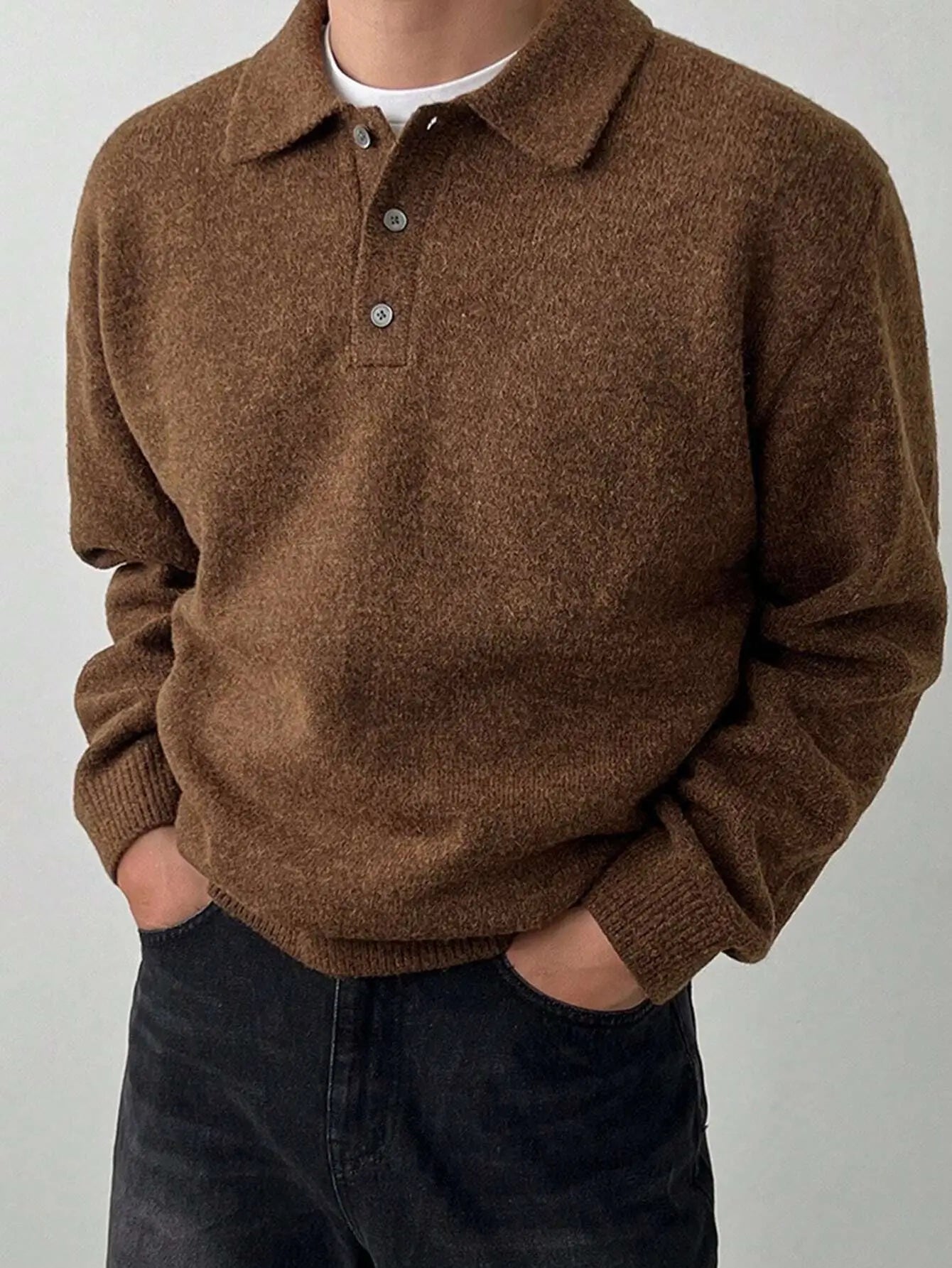 Pull tricoté marron pour homme en mélange de laine et polyester. Doté d'un col boutonné sophistiqué, de manches longues et d'une coupe droite. Poignets et taille côtelés ajoutent au confort. Couleur marron intemporelle pour complémenter toutes les tenues. Texture tricotée délicate, idéale pour l'hiver. Entretien : lavage délicat à la main ou en machine.