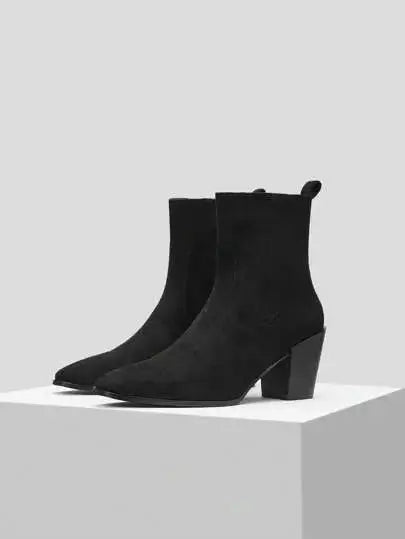 Bottines noires en imitation daim de qualité supérieure. Design élégant avec bout légèrement pointu et fermeture éclair latérale. Talons carrés pour un confort optimal et texture veloutée pour un effet luxueux. Nettoyage à sec recommandé pour maintenir l'éclat du matériau.