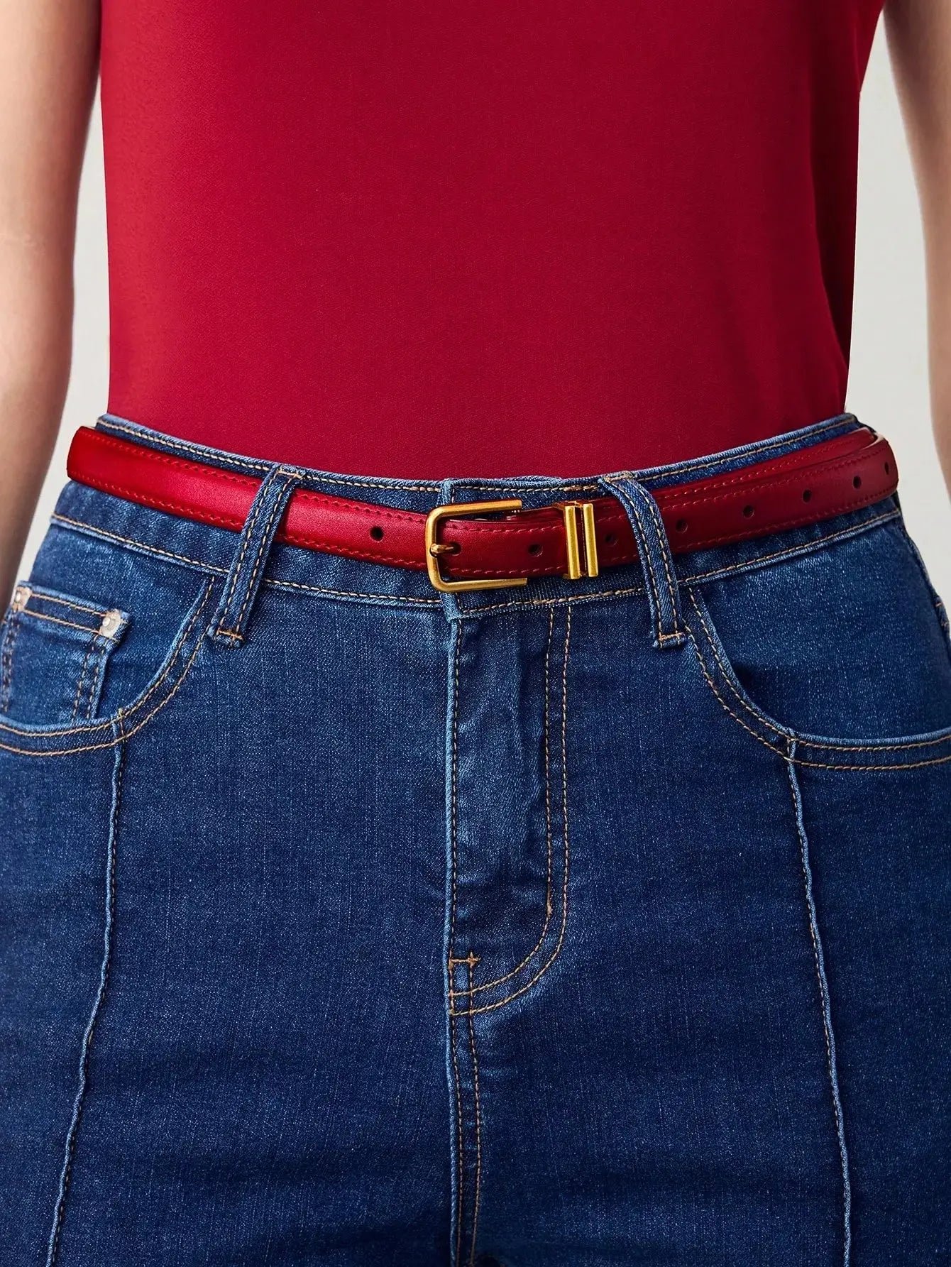 Ceinture femme en similicuir rouge, avec boucle dorée. Design lisse et finition brillante. Conçue pour ajouter une touche chic et contemporaine à vos tenues. Évitez l'exposition prolongée à l'humidité pour en préserver l'éclat.