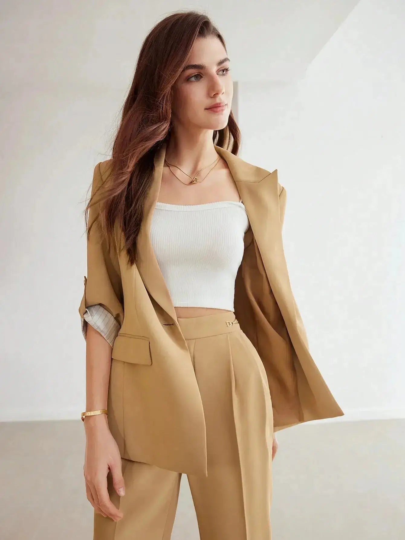 Blazer beige en polyester, tissé non extensible. Présente une coupe large avec revers, manches mi-longues retroussées et boutons décoratifs. Équipé de poches intégrées et offre une longueur classique non transparente. Disponible en beige pour une élégance discrète. Entretien par lavage en machine ou nettoyage à sec recommandé.