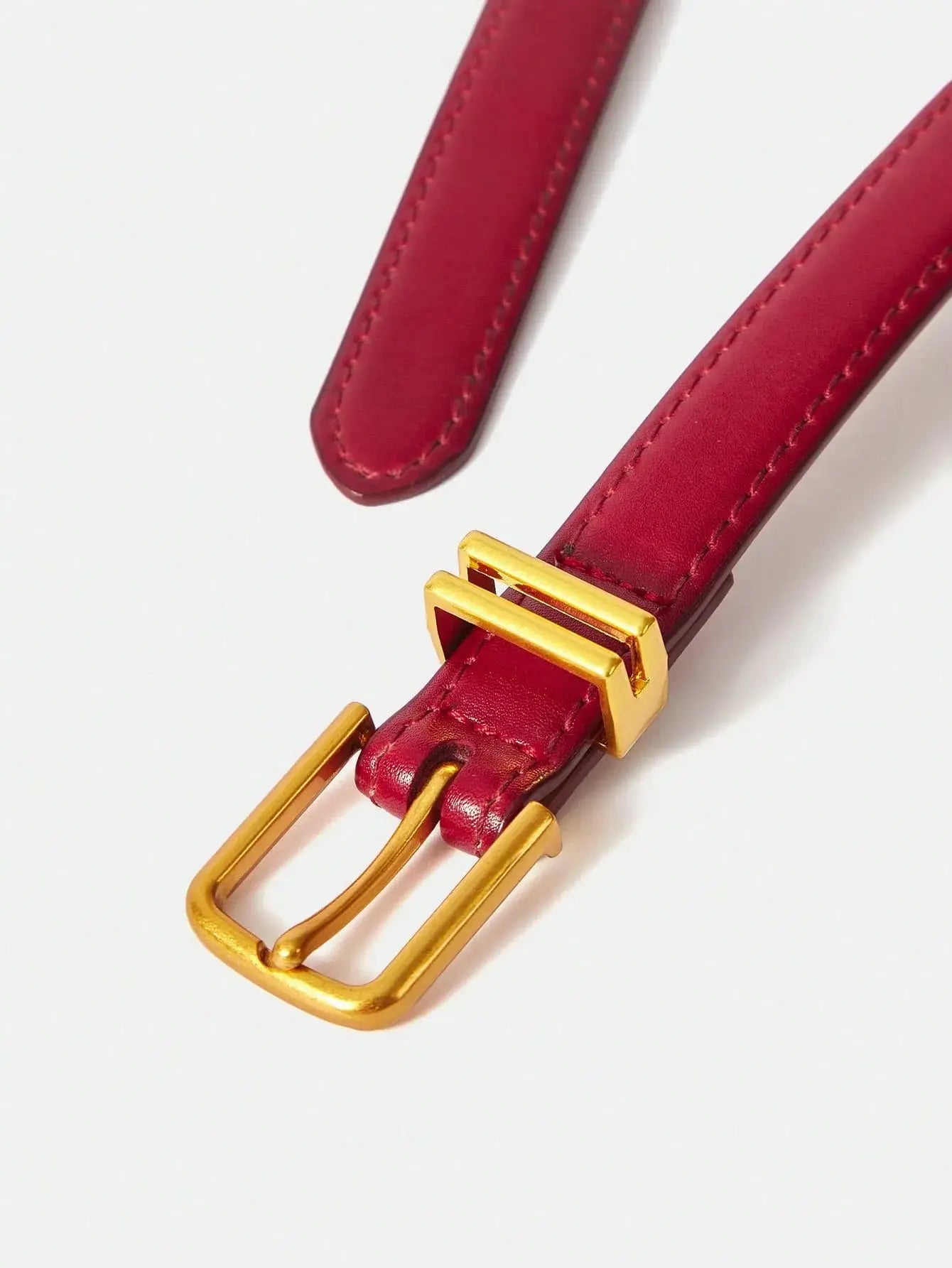 Ceinture femme en similicuir rouge, avec boucle dorée. Design lisse et finition brillante. Conçue pour ajouter une touche chic et contemporaine à vos tenues. Évitez l'exposition prolongée à l'humidité pour en préserver l'éclat.