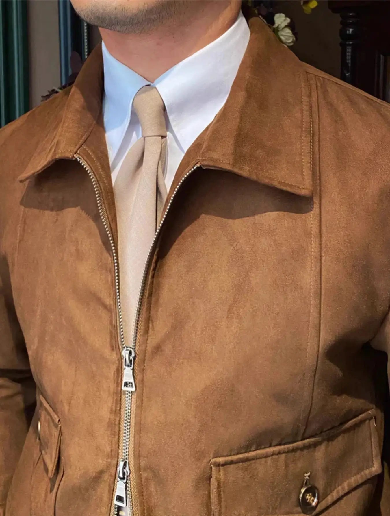 Veste vintage inspirée des années 70 avec coupe ajustée et manches longues. Fermeture éclair avant, col classique rabattu, deux poches poitrine à rabat boutonnées. Poignets et ourlet côtelés pour un style décontracté et chic. Mélange coton-polyester avec doublure satinée pour un confort durable. Disponible en brun clair, beige et gris clair. Lavage en machine à froid recommandé.